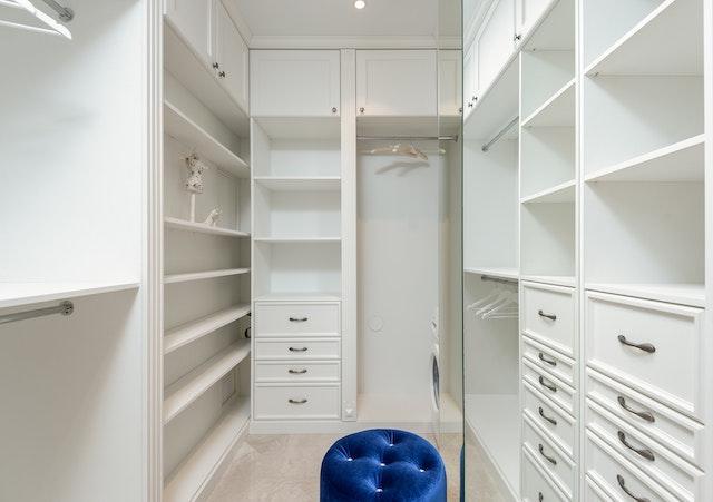 A white closed with a blue chair. One great tiny home office idea is – an office in a closet.