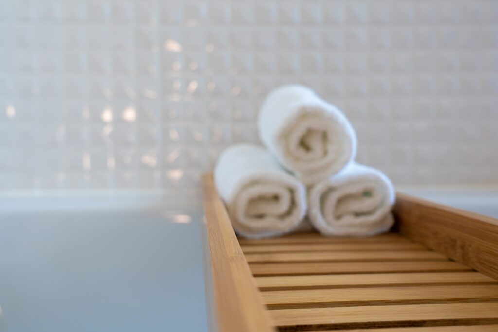 Three towels on a wooden bath rack.