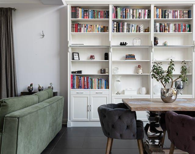 Cozy living room with wall-to-wall bookshelves filled with books and personal items