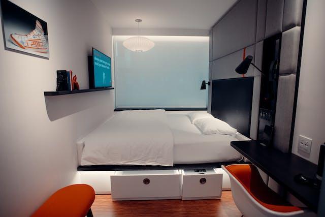 Compact modern bedroom with under-bed storage drawers and wall-mounted shelves