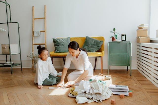 Mother and child sorting clothes in a bright, airy room with minimalistic furniture