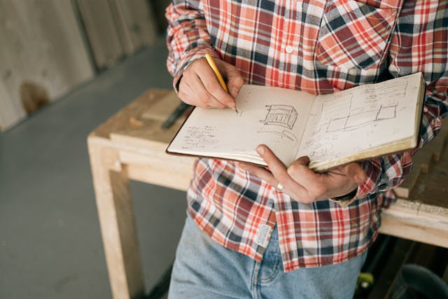 Man drawing blueprints for ways to repurpose old furniture