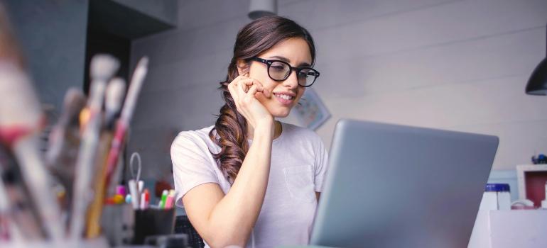 A smiling woman using a laptop